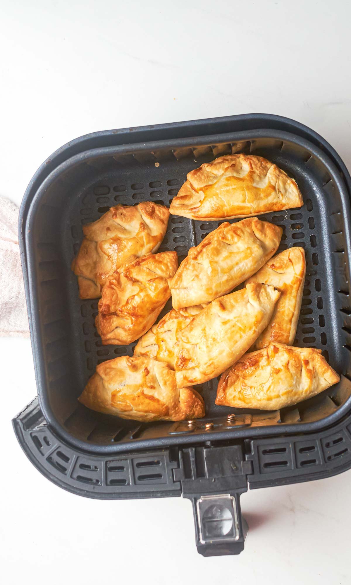 top down view of the air fryer empanadas inside the air fryer basket