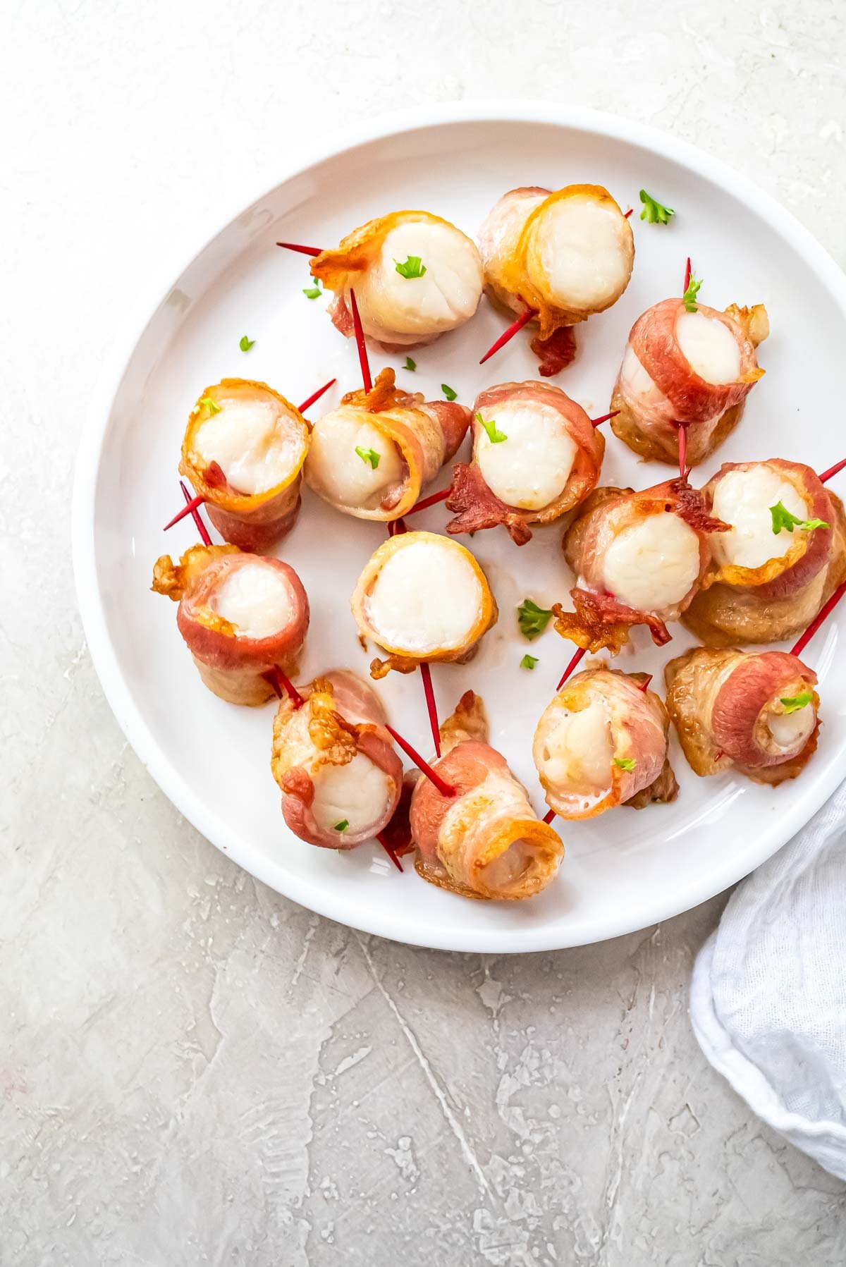 a plate filled with bacon wrapped scallops air fryer