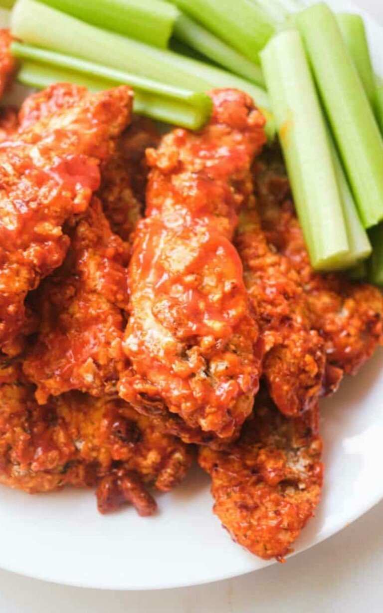 Buffalo Chicken Tenders in a white plate with celery.