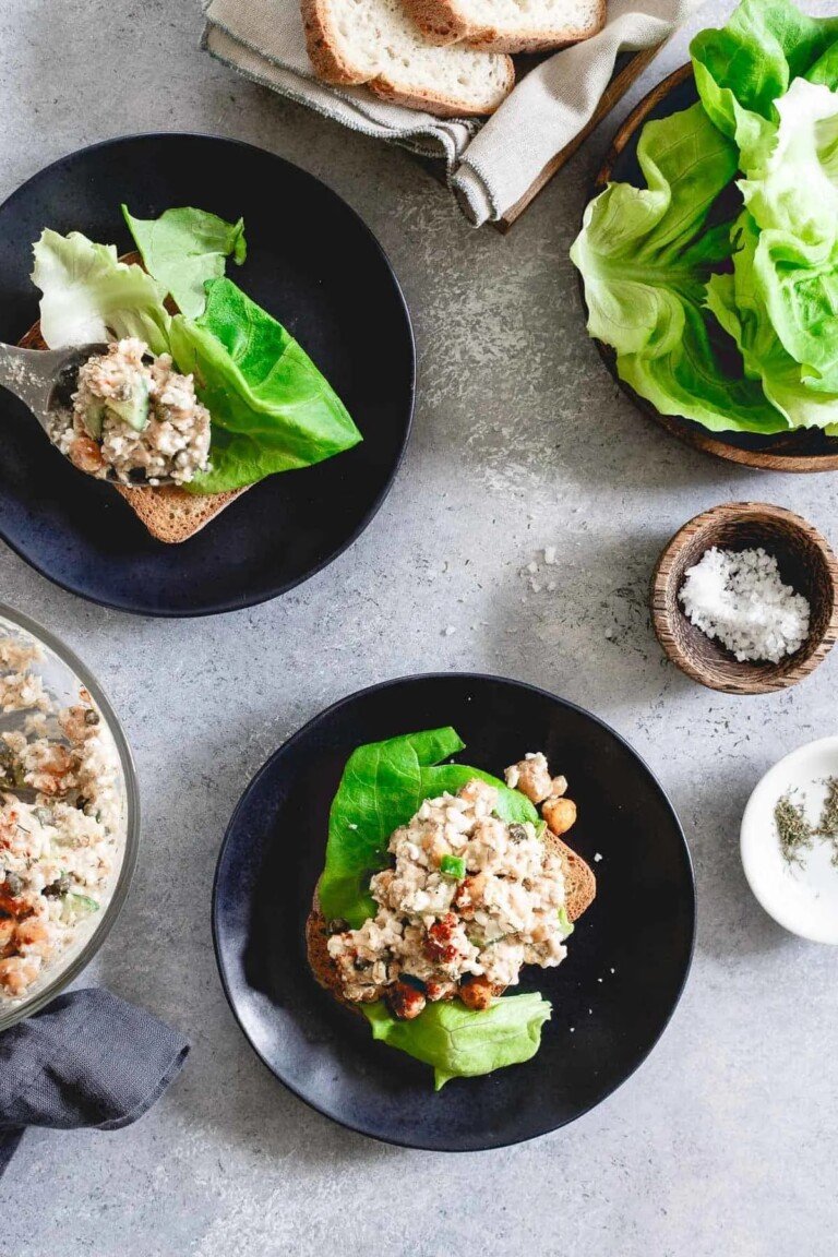 two servings of dill salmon salad on black plates