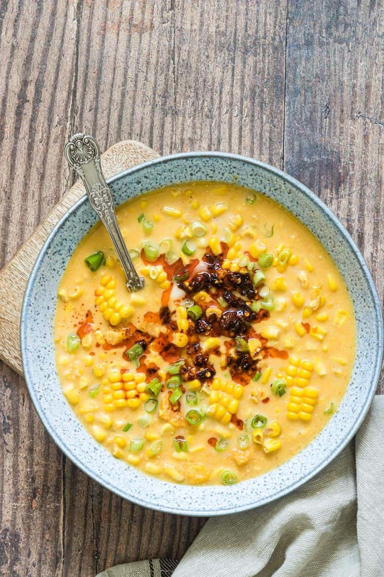 a bowl of instant pot corn chowder on a table with a spoon in it