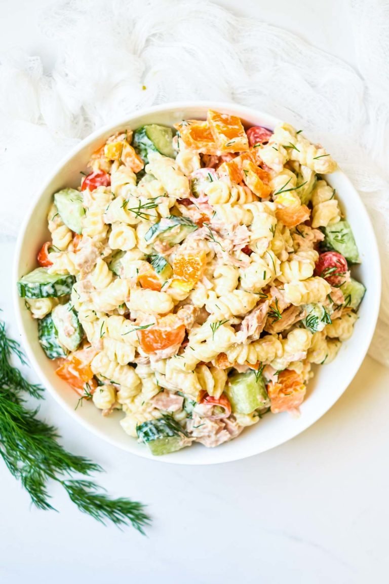 Creamy tuna pasta in a white serving bowl with garnish.