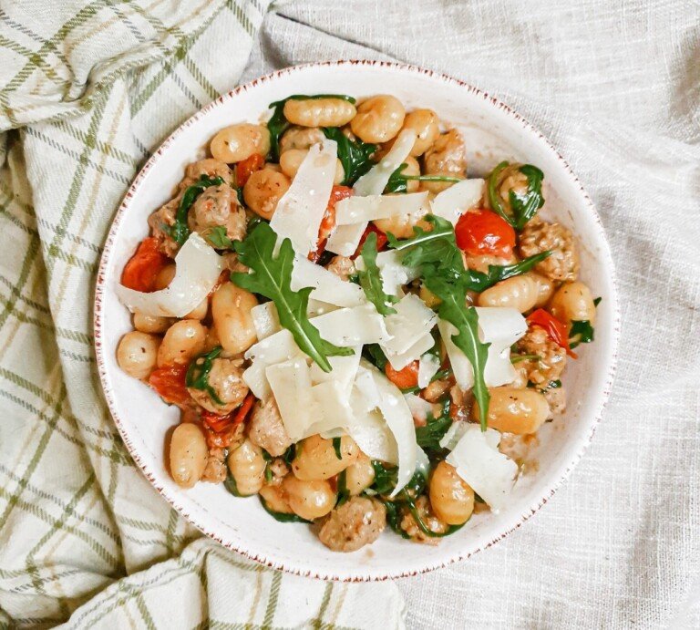 Italian Sausage Meatballs with Fried Gnocchi in a white bowl.