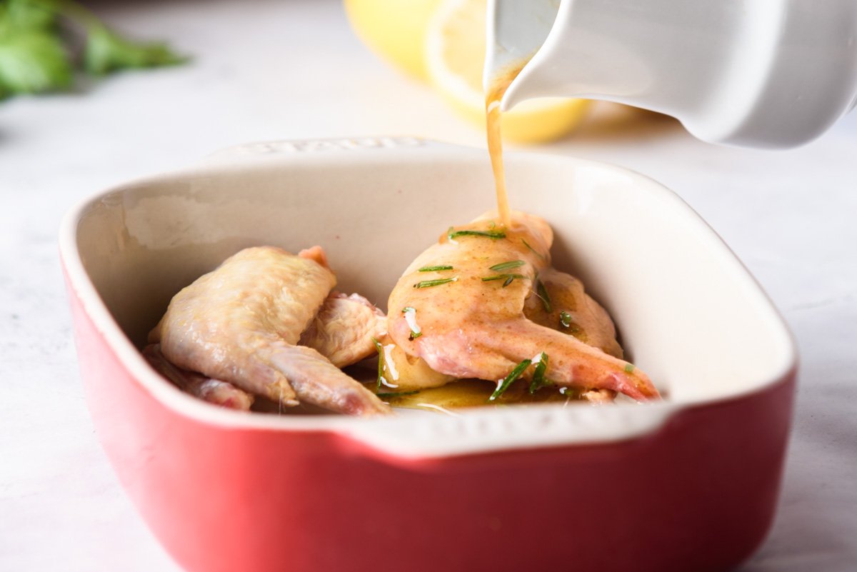 turkey marinade being poured on top of meat inside a baking dish