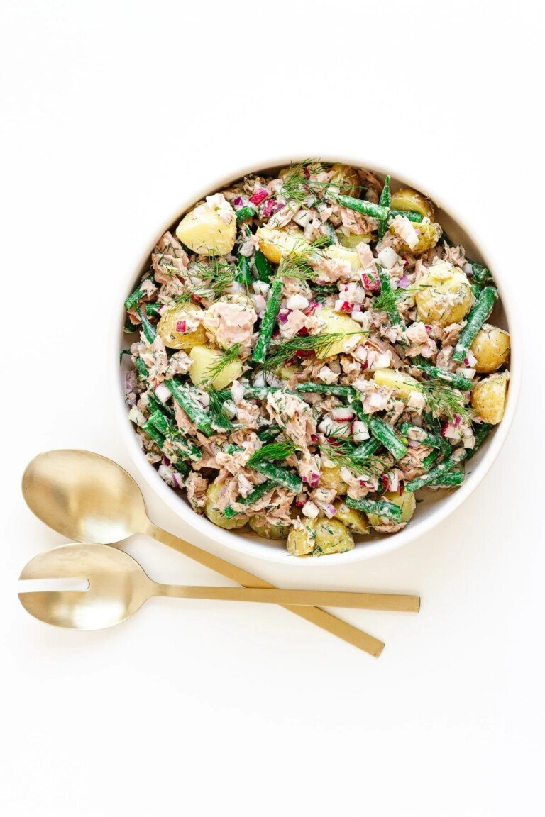 Tuna Potato Salad in a white salad bowl with serving spoons.