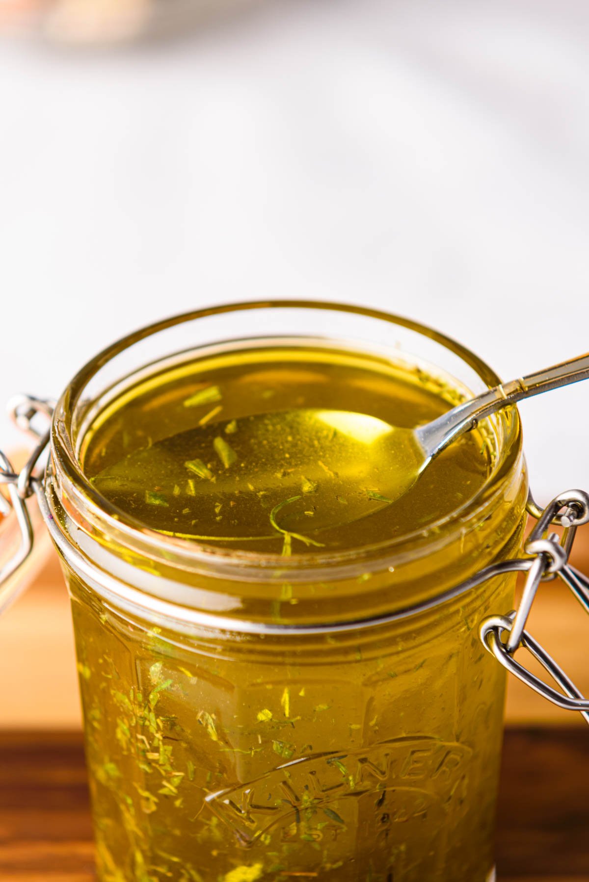 a spoon removing some of the turkey marinade from a glass jar