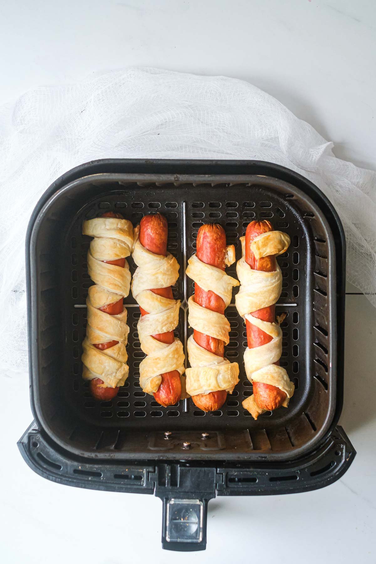 the cooked air fryer mummy dogs recipe inside the air fryer basket