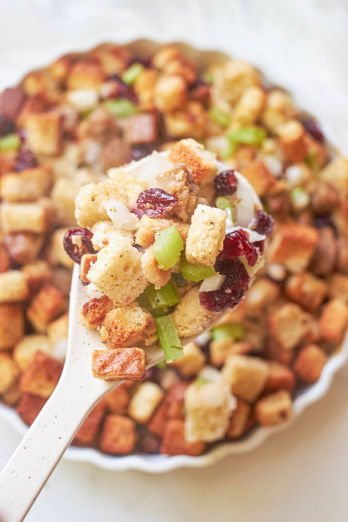 close up view of a spoonful of air fryer stuffing being removed from the baking dish