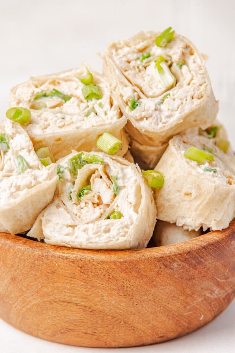 Chicken taco pinwheels on a wooden board.