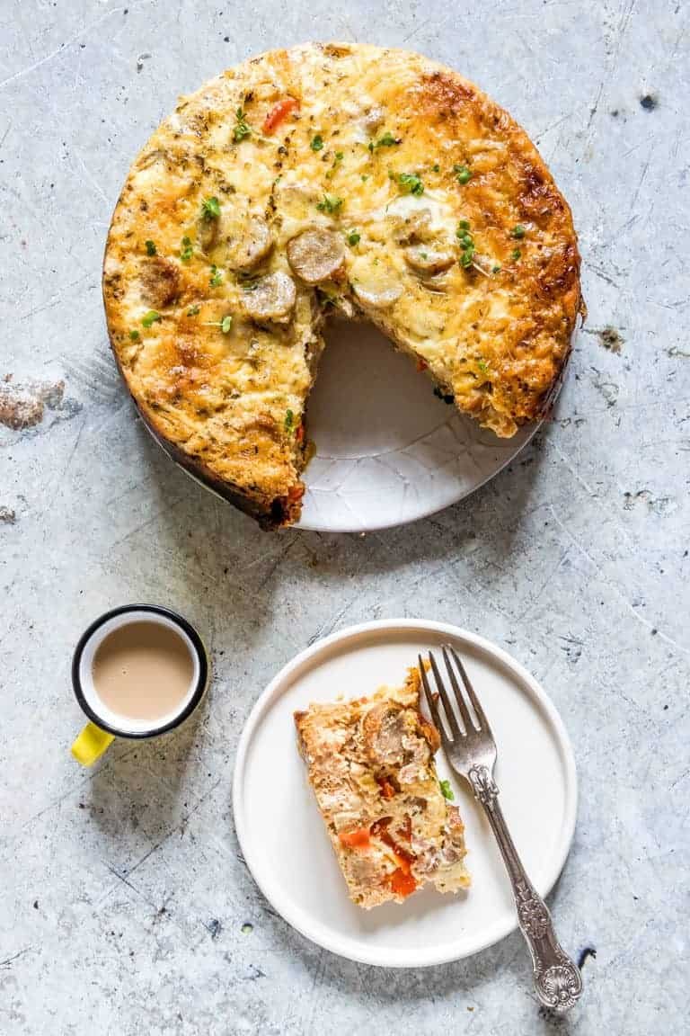 Top-down view of Crockpot Breakfast Casserole with one slice removed and served on a white plate