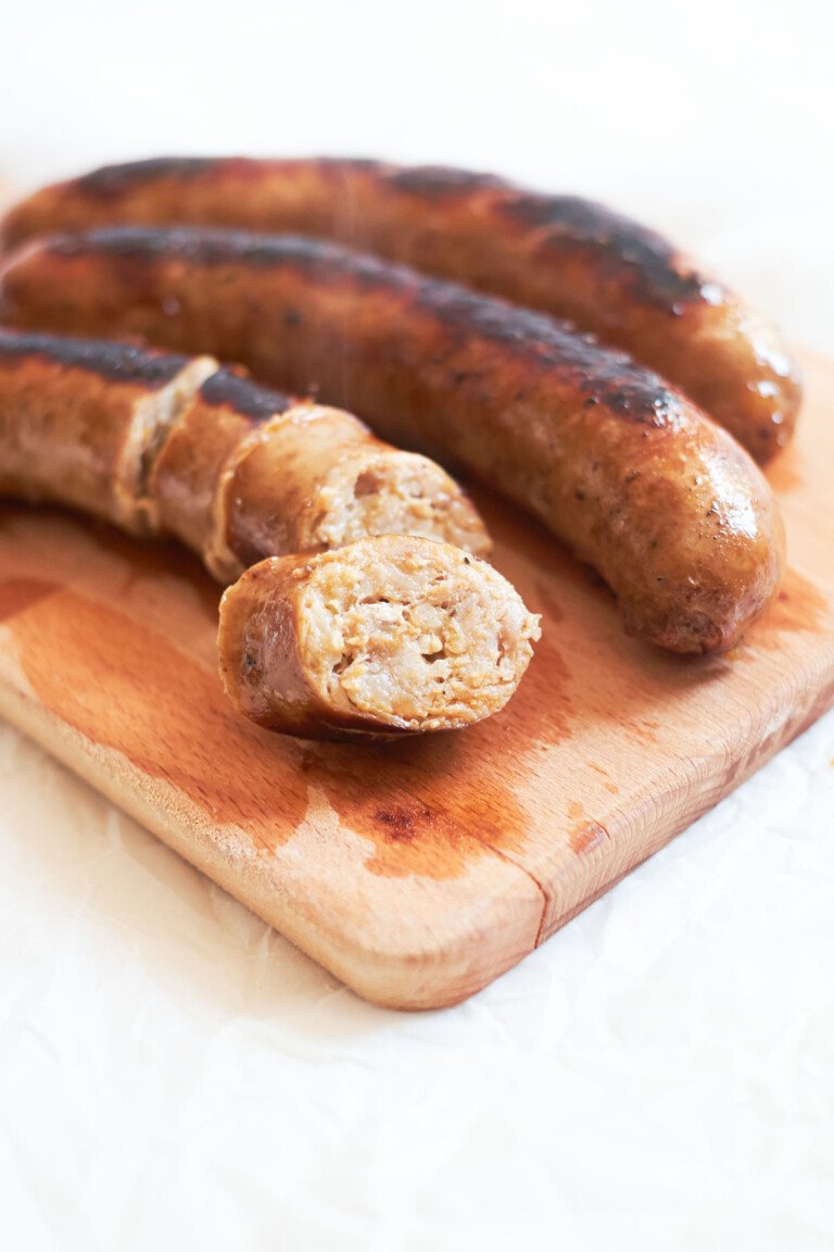 sliced Italian sausages from the how to cook italian sausage recipe on a wood board ready to be served