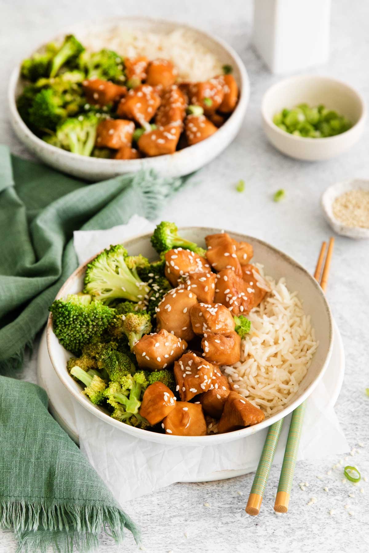 two servings of instant pot teriyaki chicken on a table with cloth napkins