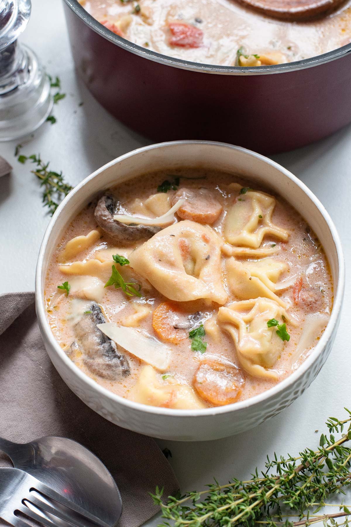 the completed tomato tortellini soup served in a white bowl