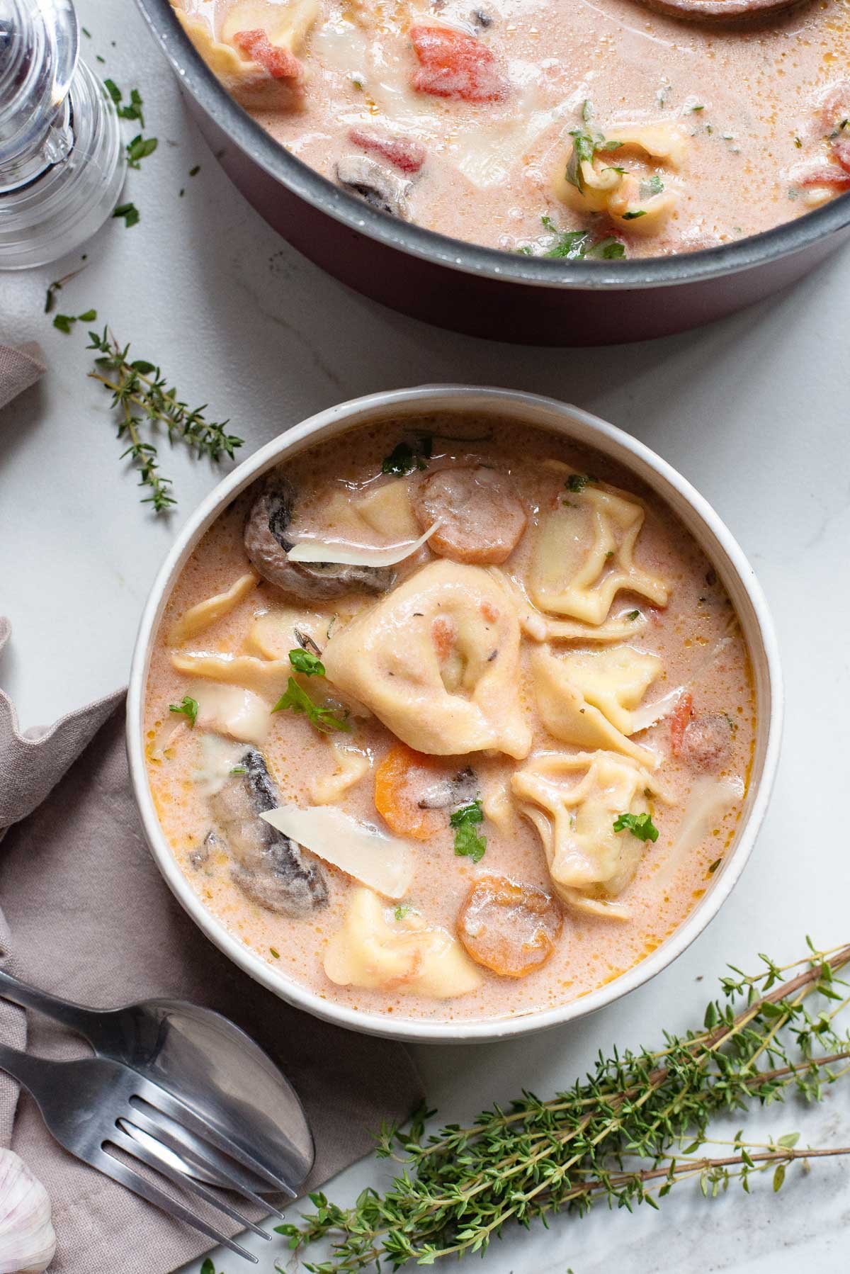 one serving of tomato tortellini soup on a table